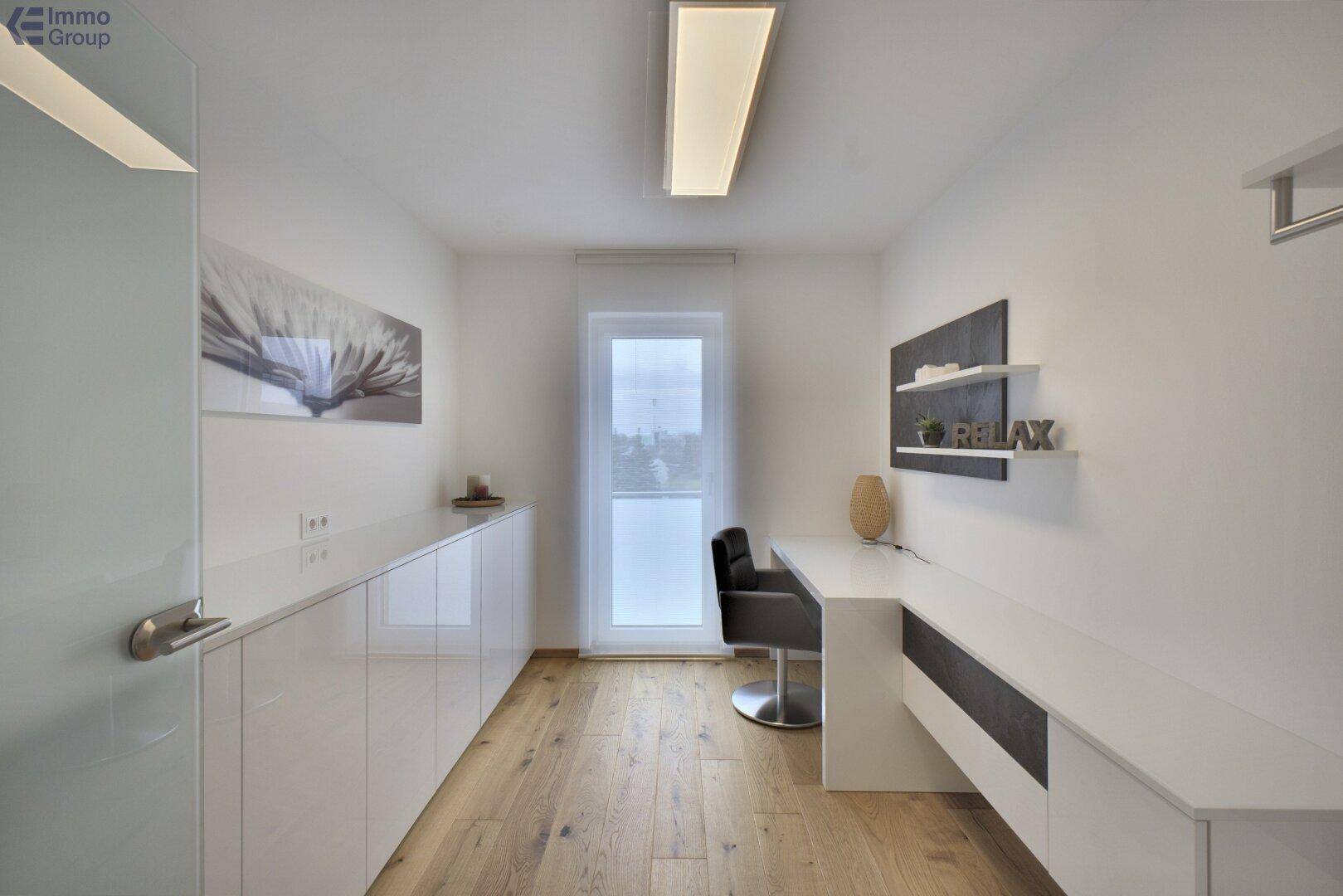 Helles Büro mit langen Arbeitsflächen, viel Stauraum und Fenster.