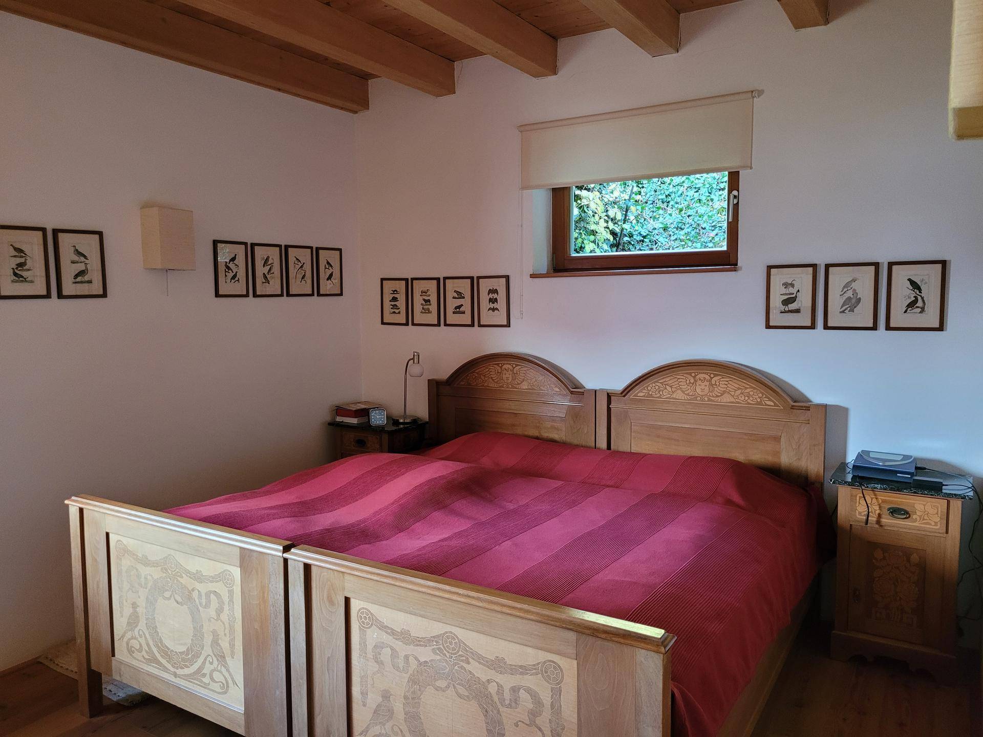 Gemütliches Schlafzimmer mit traditionellem Holzbett und Holzboden, umgeben von schlichter Dekoration.