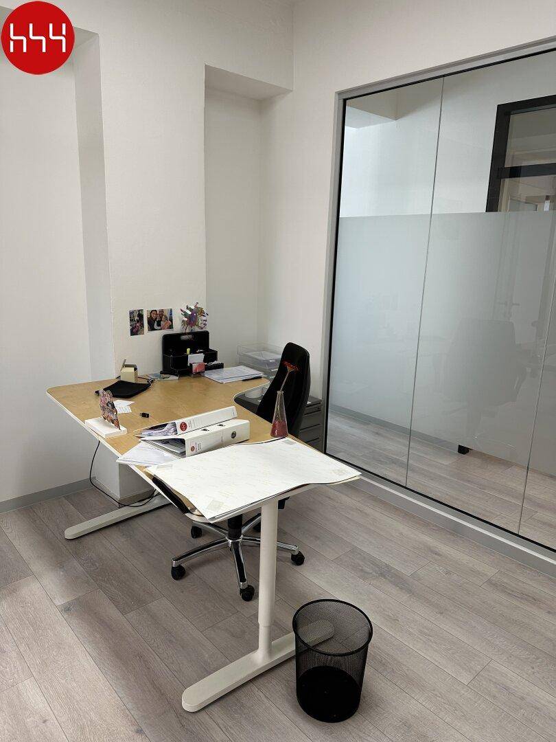 Helles Einzelbüro mit modernem Schreibtisch, Bürostuhl und einer großen Fensterfront mit Milchglasfolie.