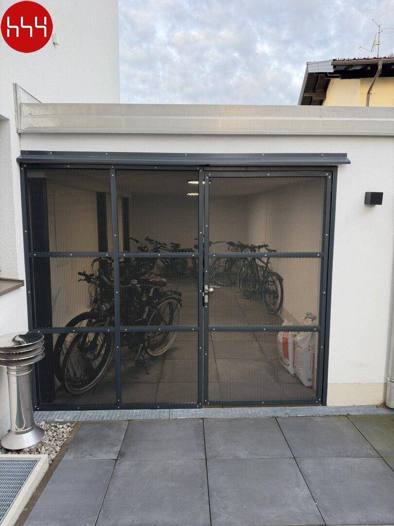Abschließbarer Fahrradraum im Außenbereich des Gebäudes, ideal für sichere Aufbewahrung.