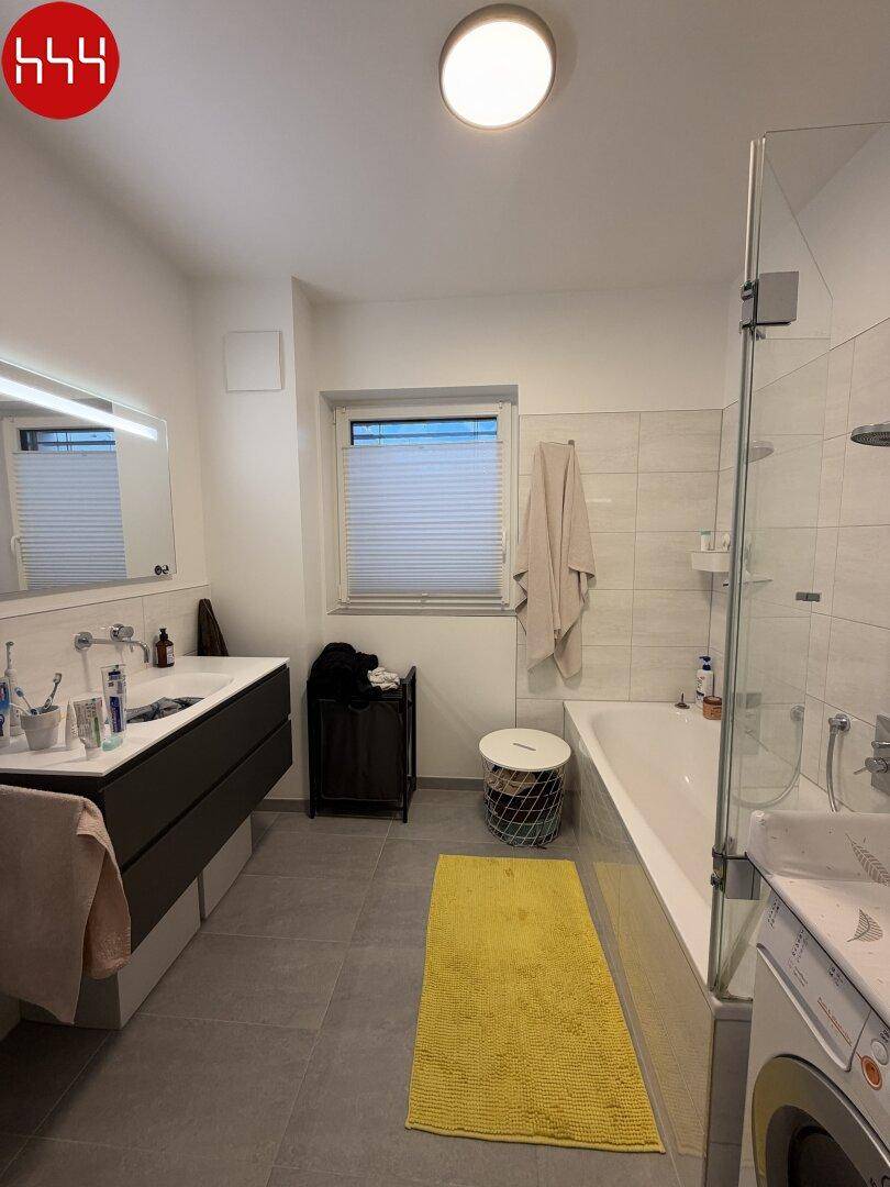 Modernes Badezimmer mit Badewanne, Dusche und großem Waschtischunterschrank.
