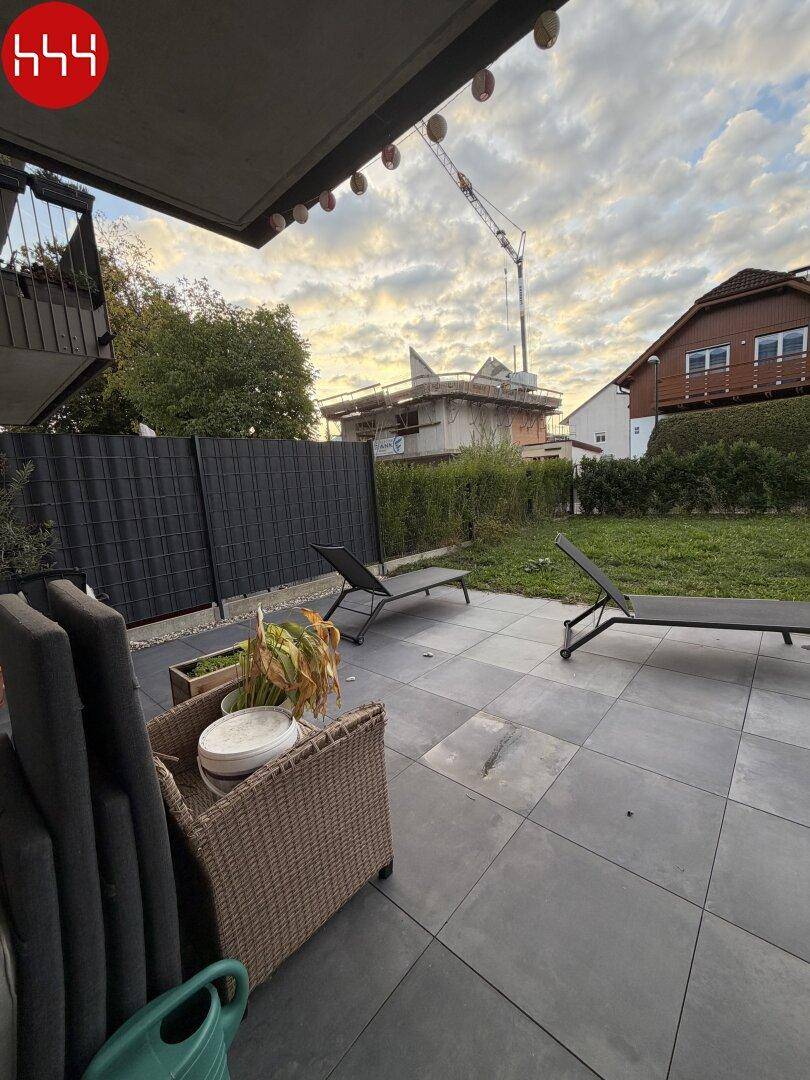 Große gepflasterte Terrasse mit Gartenmöbeln und Blick auf die Umgebung.