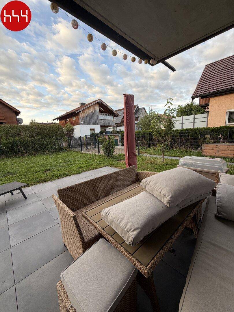 Gemütliche Terrasse mit Rattanmöbeln und Kissen, ideal für entspannte Stunden im Freien.