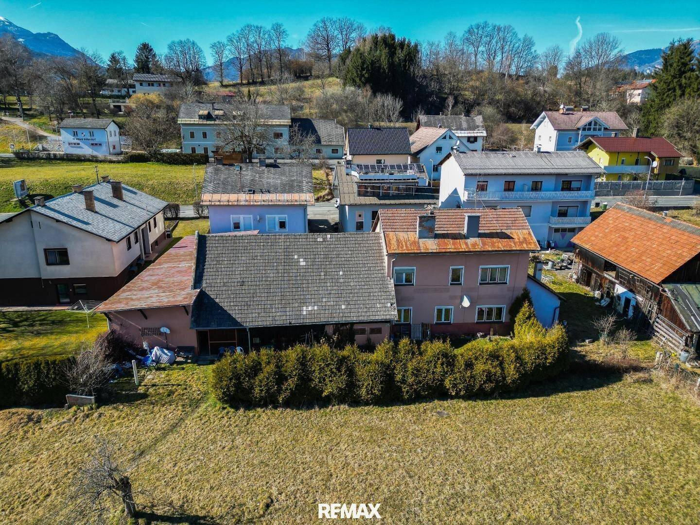 Weitläufige Luftaufnahme des Anwesens in ländlicher Umgebung mit Bergen im Hintergrund.