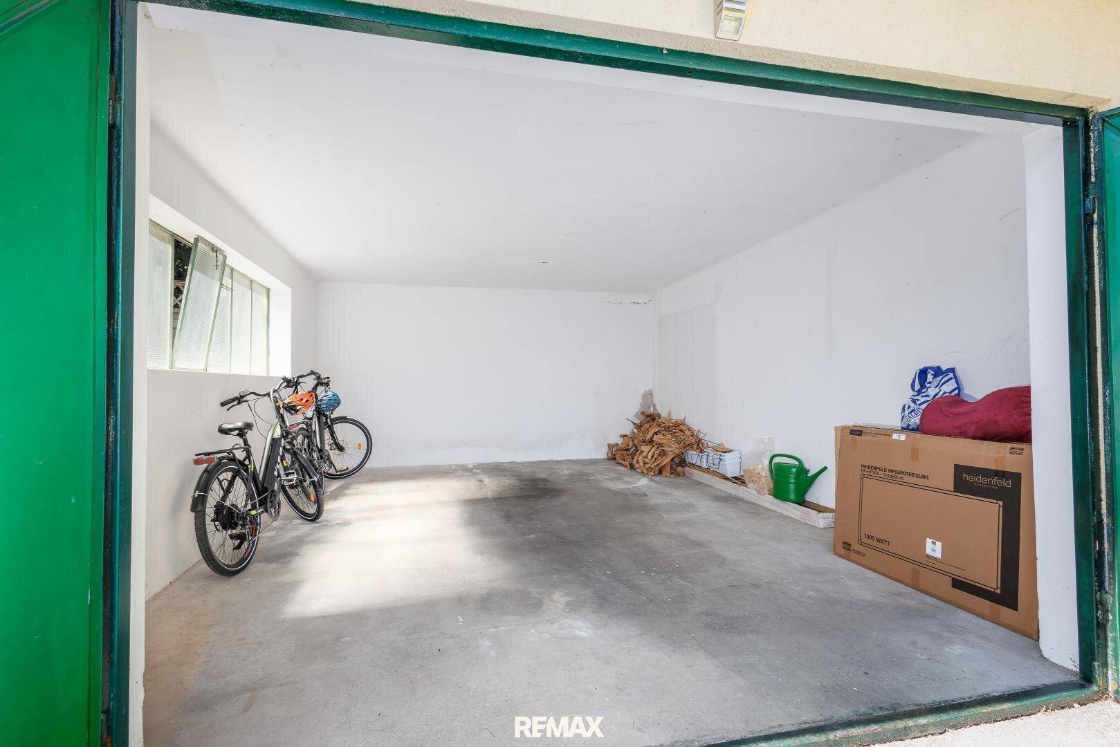 Geräumige Garage mit Betonboden, Platz für Fahrräder und zusätzlichen Stauraum.
