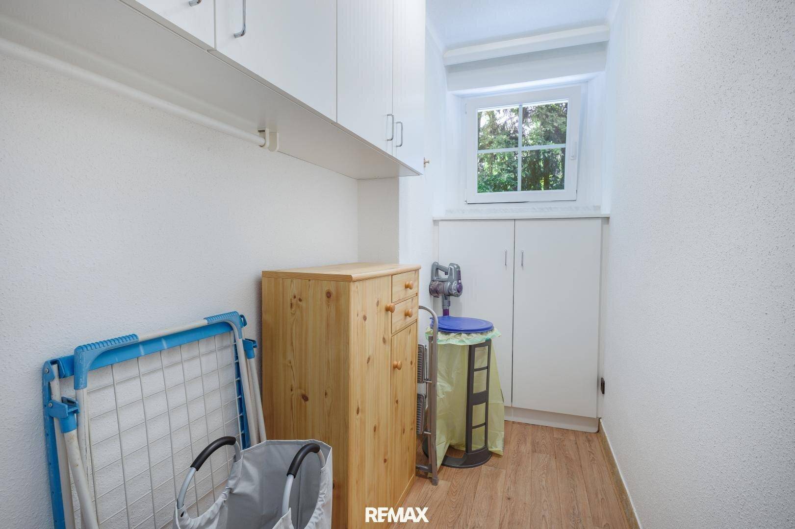 Praktischer Abstellraum mit Fenster, Regalen und Platz für Haushaltsgeräte und Wäsche.