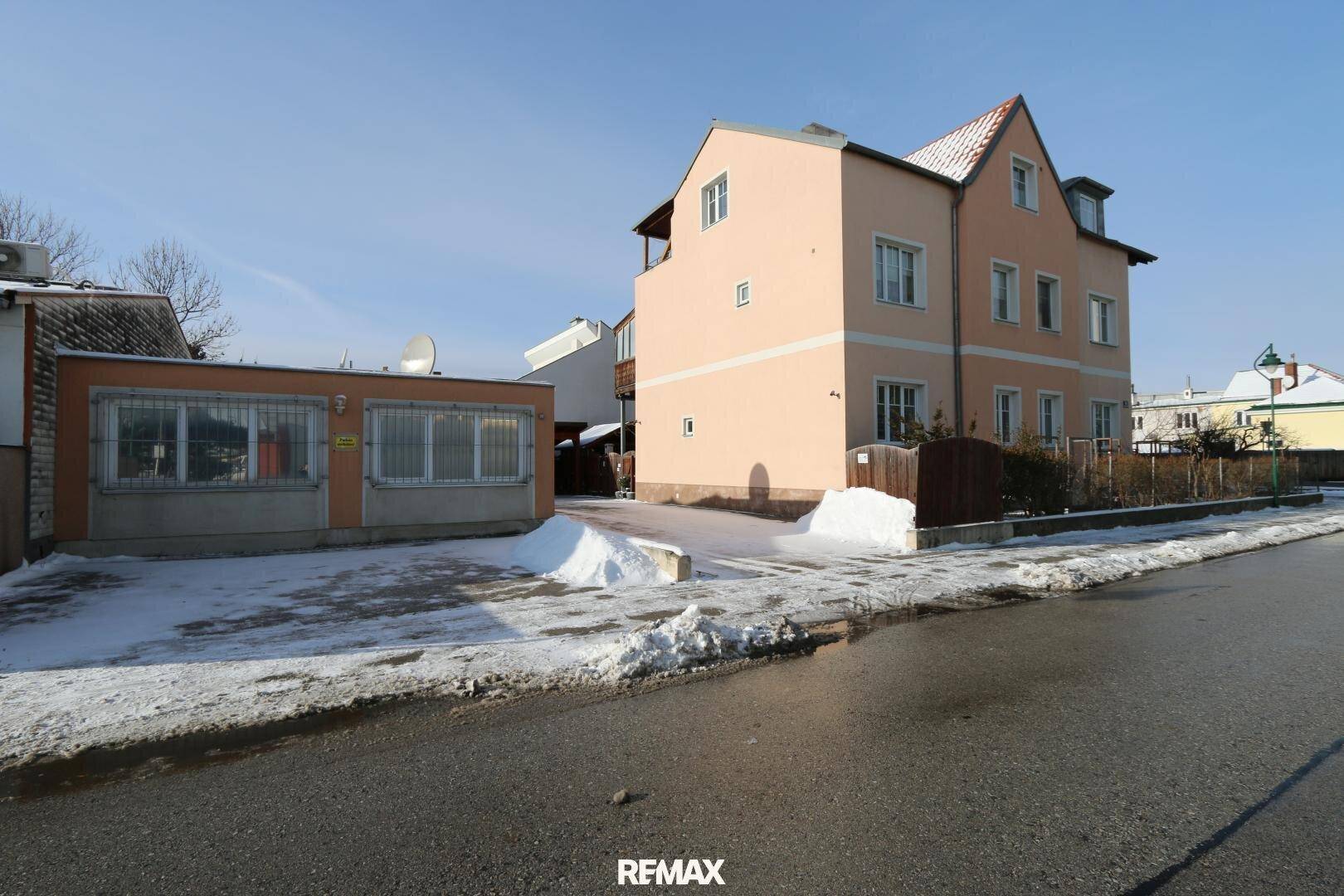 Vorderansicht des Anwesens von der Straße aus, mit Haupthaus und Nebengebäude im Schnee.