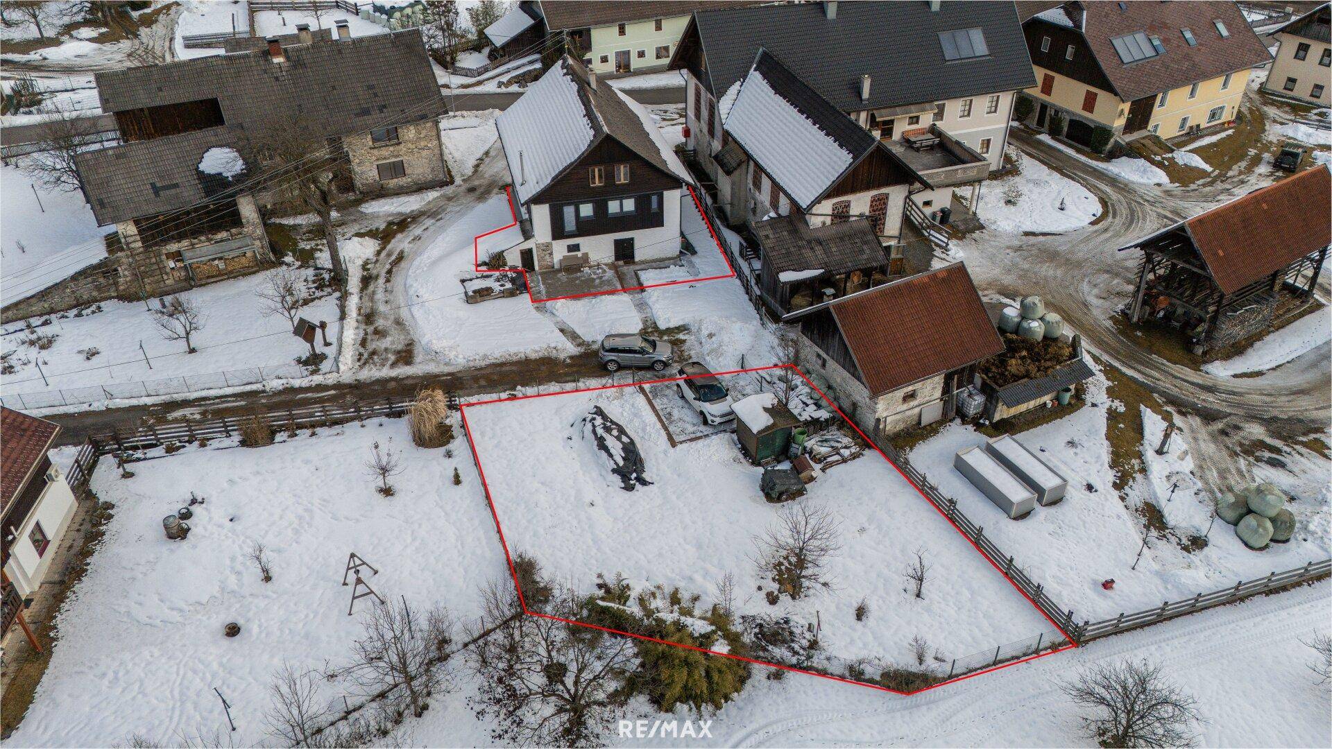 Luftaufnahme des Anwesens mit umliegenden Gebäuden und verschneiter Landschaft.