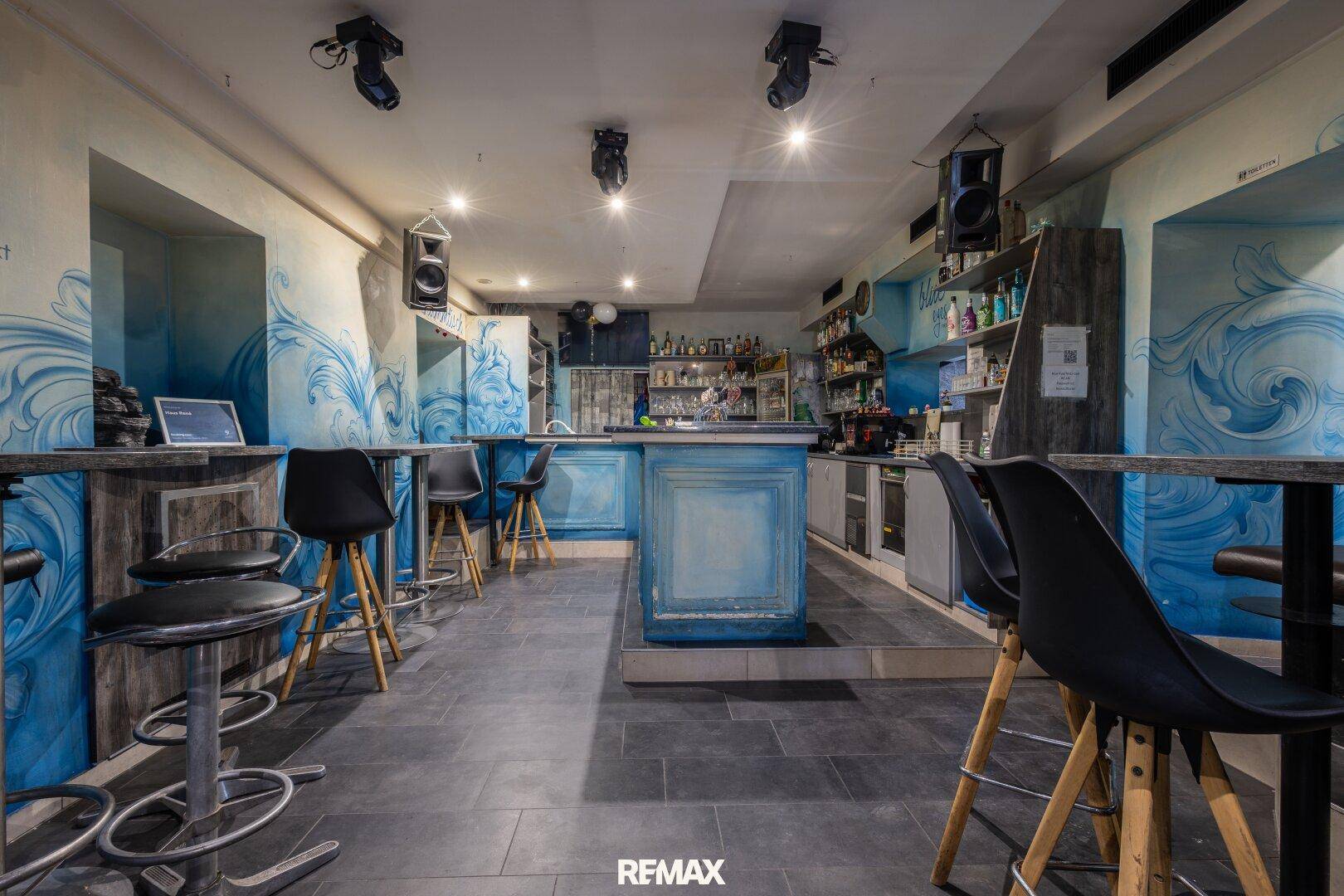 Bar im Untergeschoss mit blauen Wandmalereien und zahlreichen Sitzgelegenheiten.