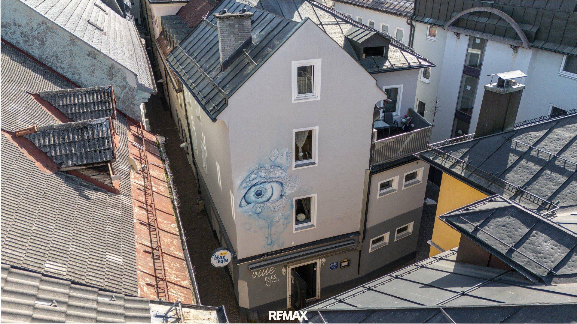 Historisches Gebäude mit markanter Fassadenmalerei und Dachterrasse in der Altstadt.