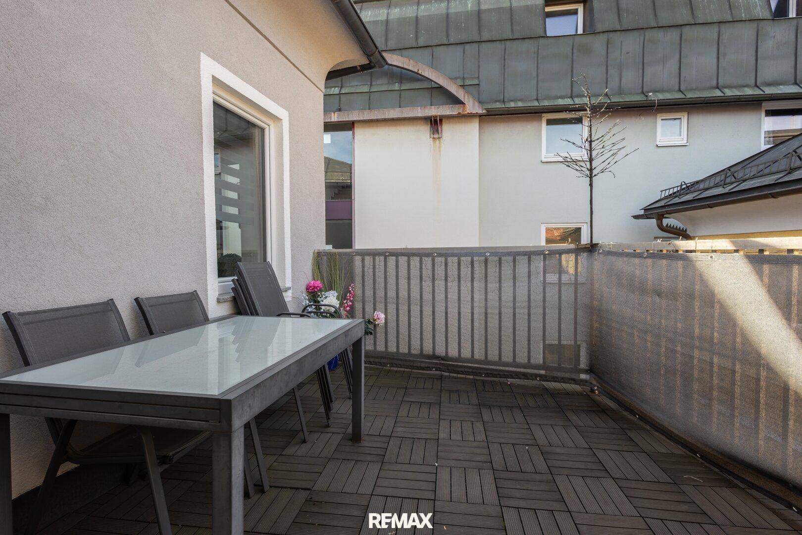 Gemütliche Terrasse mit Holzbodenfliesen und Gartenmöbeln, ideal für entspannte Stunden im Freien.