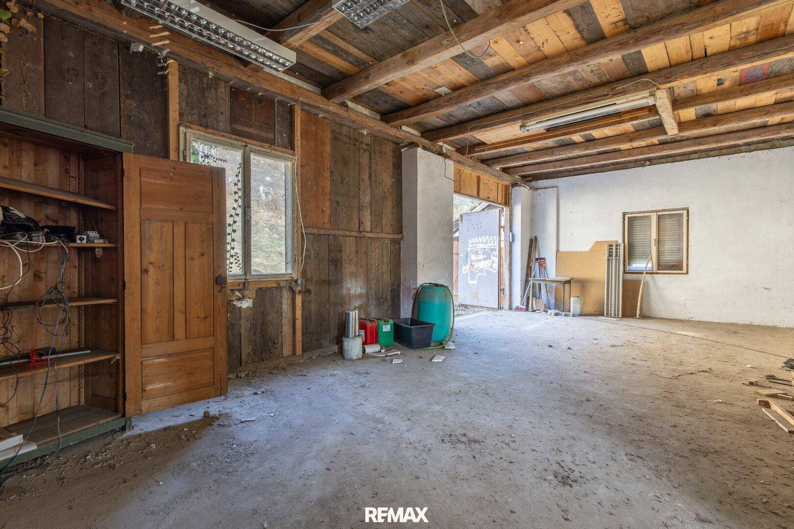 Geräumiger Abstellraum mit Holzwänden und -decken, der direkten Zugang nach draußen bietet.