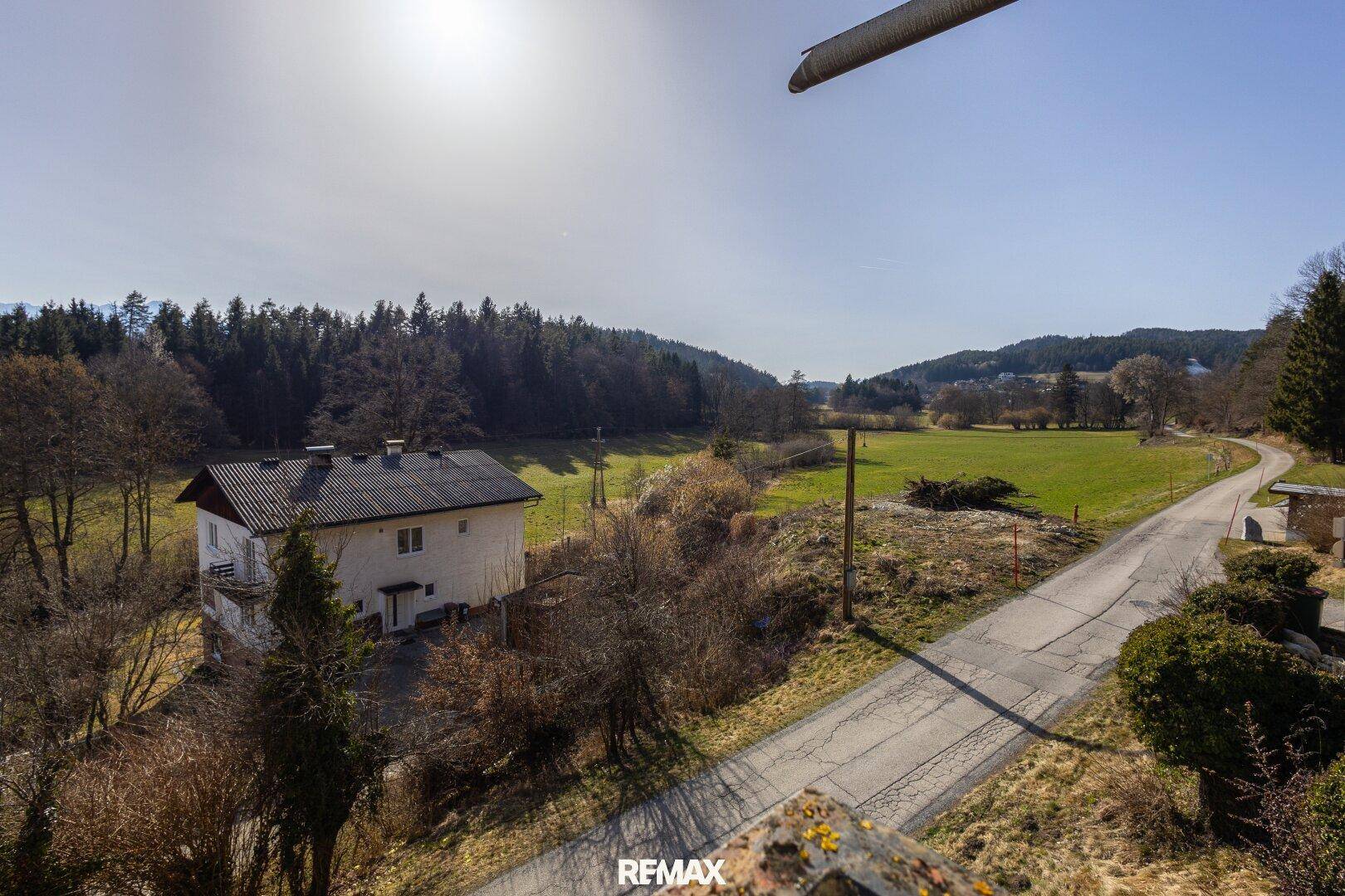 Weitläufiger Blick auf das Haus in einer idyllischen ländlichen Umgebung mit Wiesen und Wäldern.