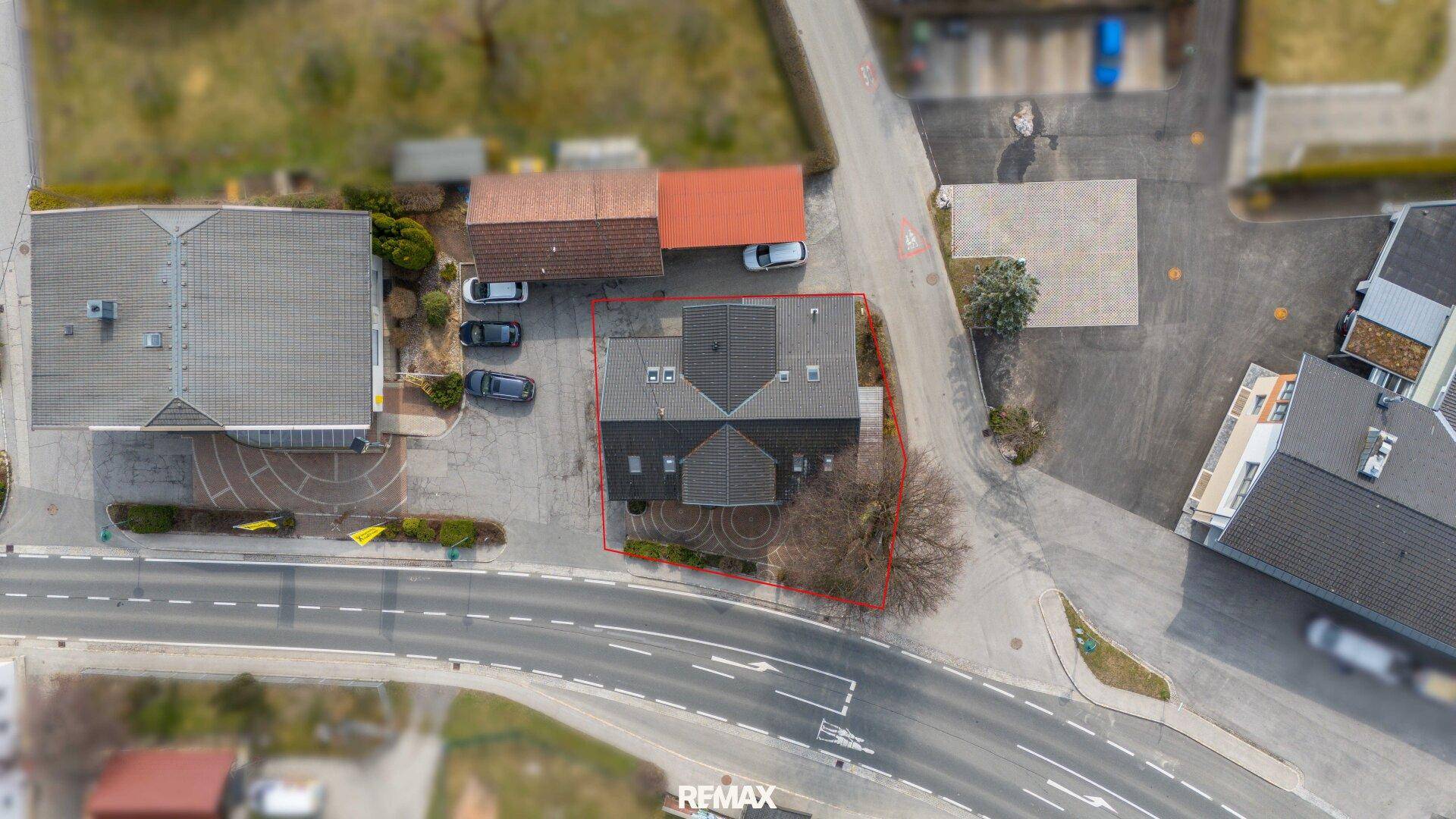 Luftaufnahme des Gebäudes mit umliegender Bebauung und Straße.