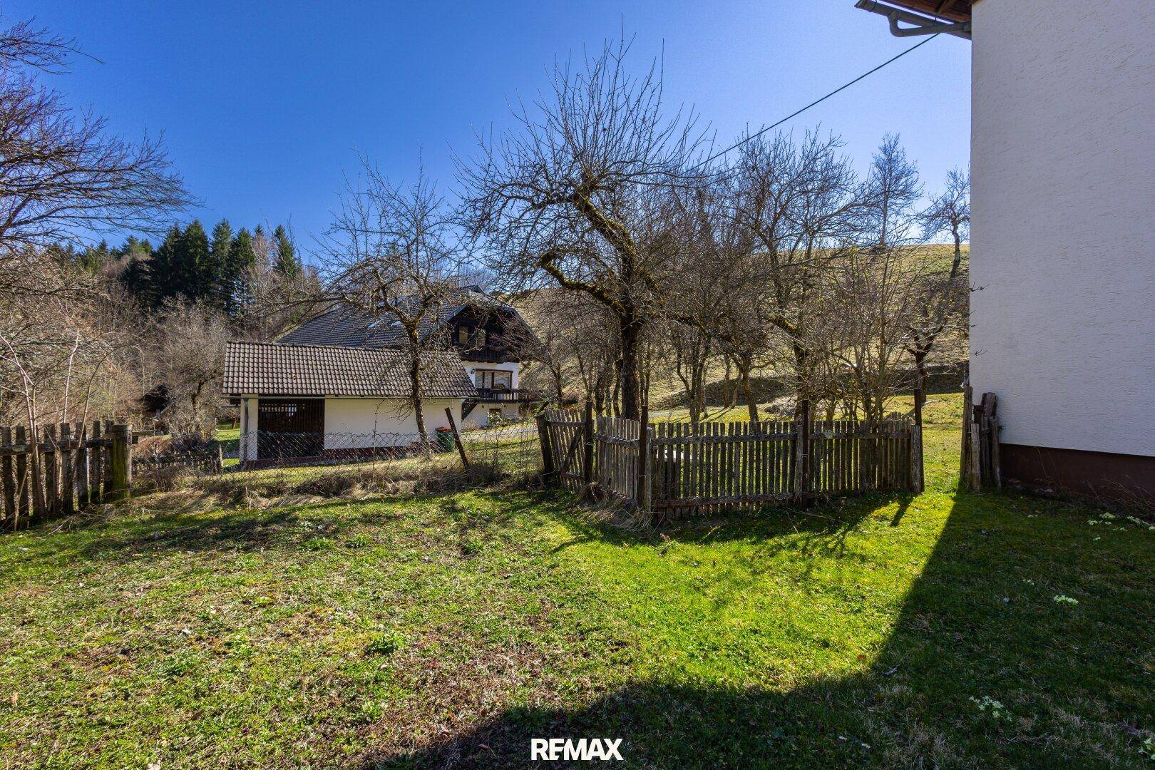 Garten mit alten Bäumen und Holzzaun, bietet viel Platz und Privatsphäre.