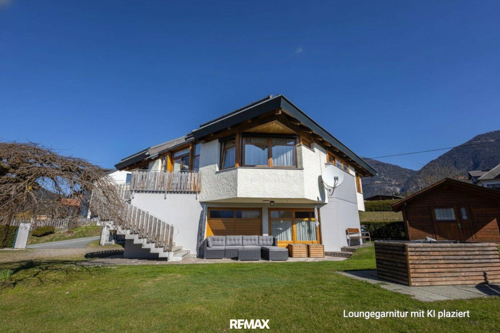 Terrasse mit Loungemöbeln und Blick auf die umliegende Berglandschaft.