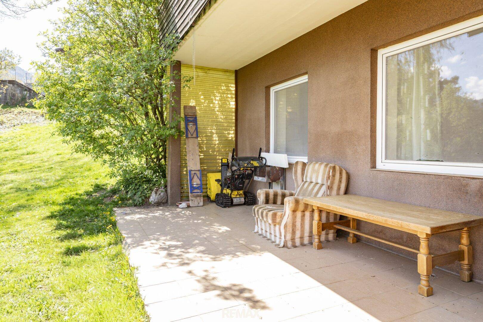 Gemütliche Terrasse am Haus mit Sitzgelegenheiten und direktem Zugang zum grünen Gartenbereich.