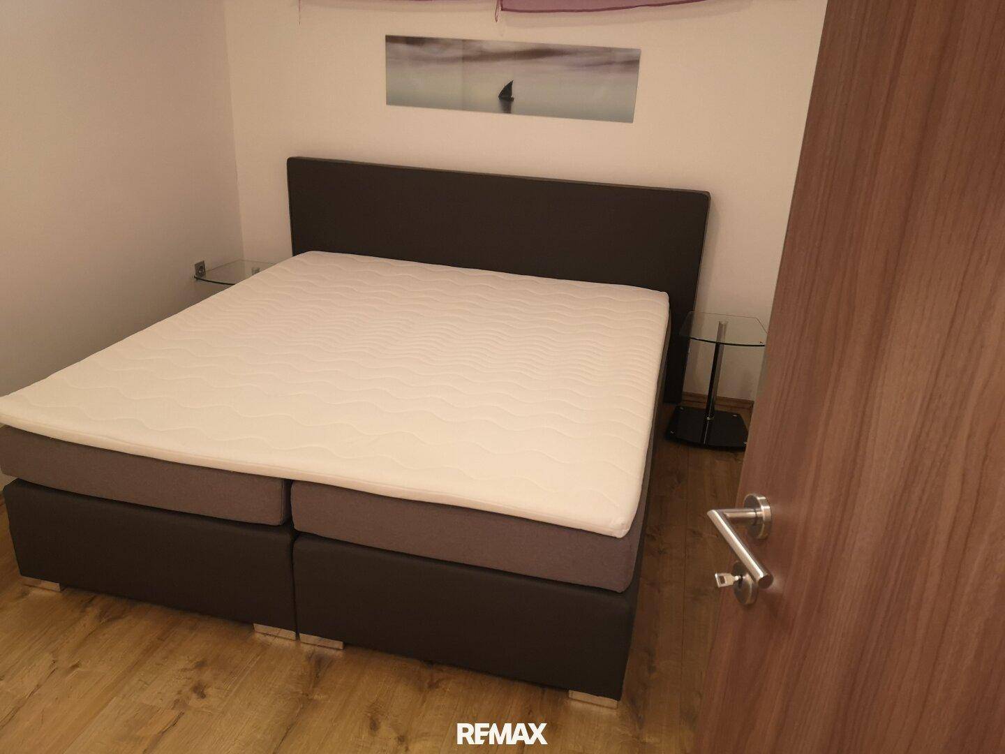 Schlafzimmer mit Doppelbett und modernen Nachttischen, ausgestattet für Komfort.