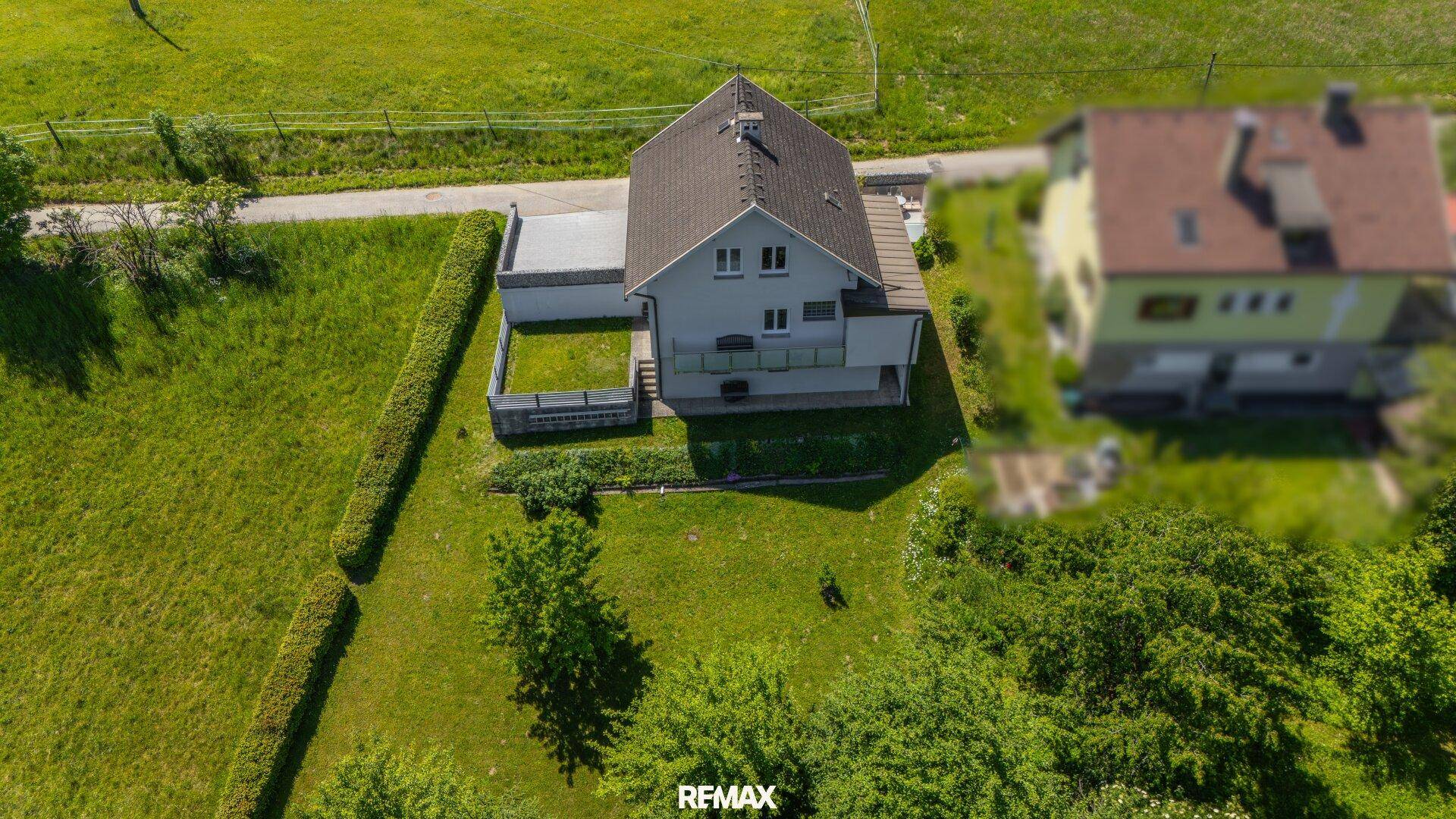 Gesamtansicht des Grundstücks von oben mit Haus, Garten und angrenzenden Grünflächen.