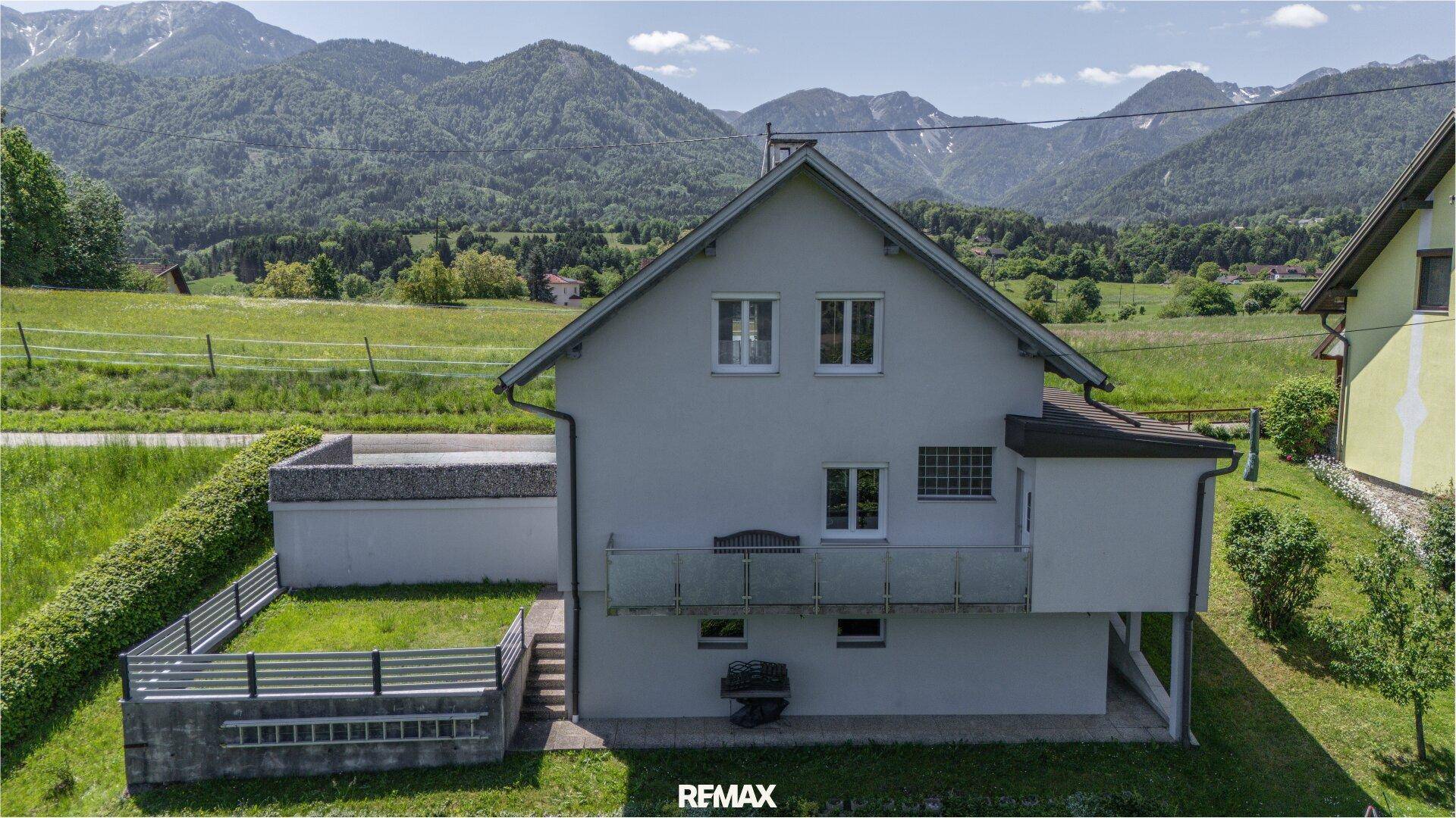 Seitenansicht des Hauses mit Balkon und Blick auf die beeindruckende Berglandschaft.