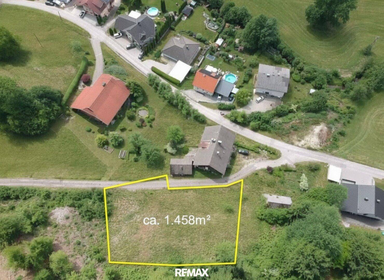 Luftaufnahme eines Grundstücks von ca. 1.458m² mit umliegenden Häusern und Straßen.