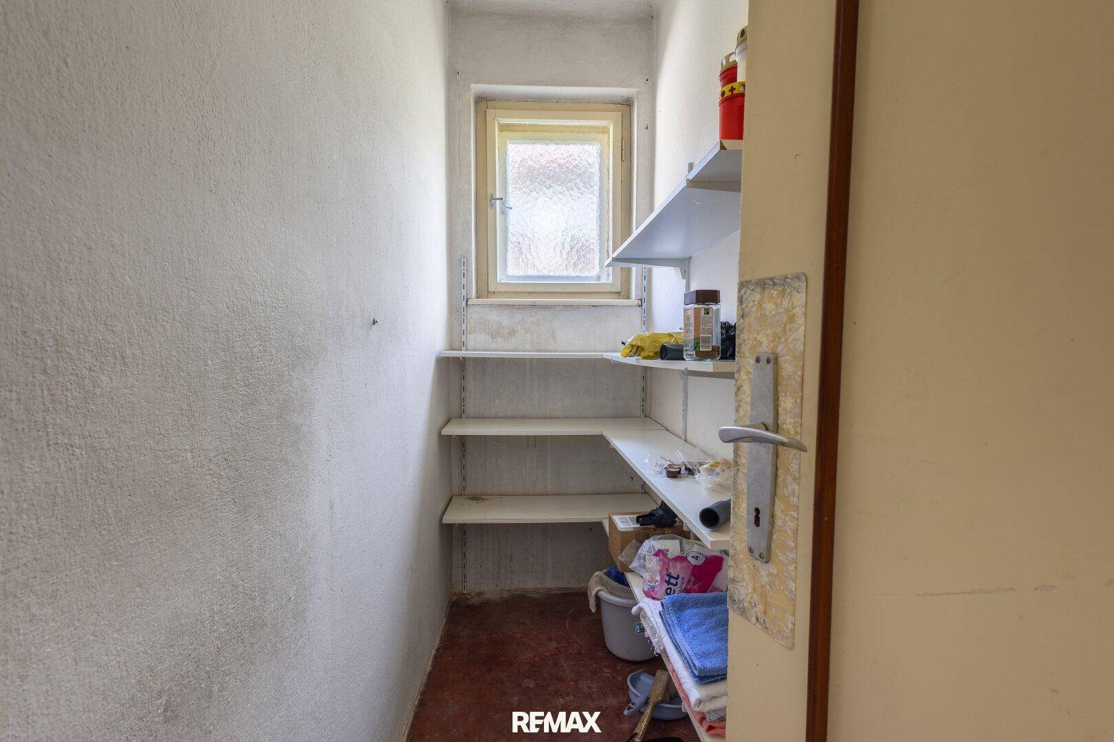 Abstellraum mit Regalen, Fenster und Stauraum für Haushaltsgegenstände.