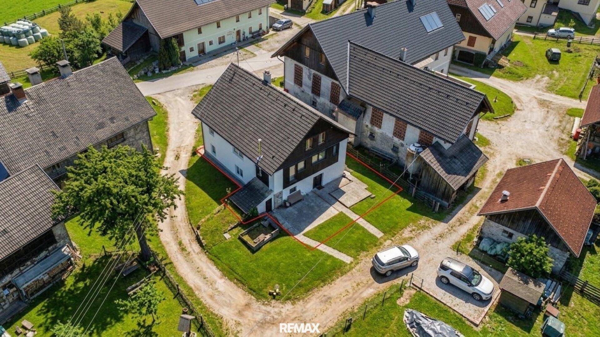 Luftaufnahme des Hauses mit angrenzenden Gebäuden und der grünen Umgebung.