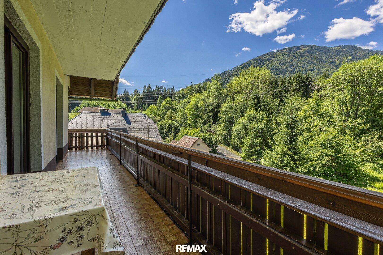 Geräumiger Balkon mit Fliesenboden und weitem Blick auf die Berge.