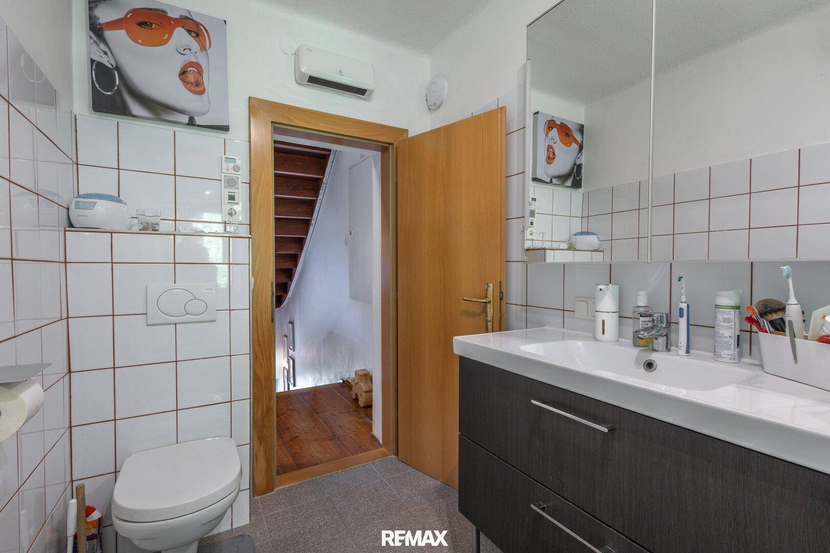 Kleines Badezimmer mit WC, Einzelwaschbecken und direktem Zugang zum Treppenhaus.