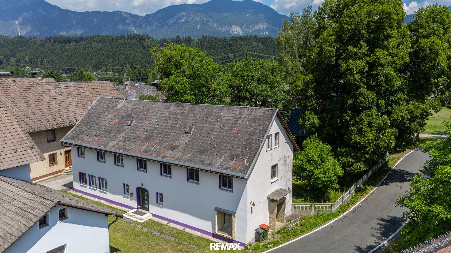Luftaufnahme des weißen Hauses mit umliegenden Gebäuden und viel Grün.