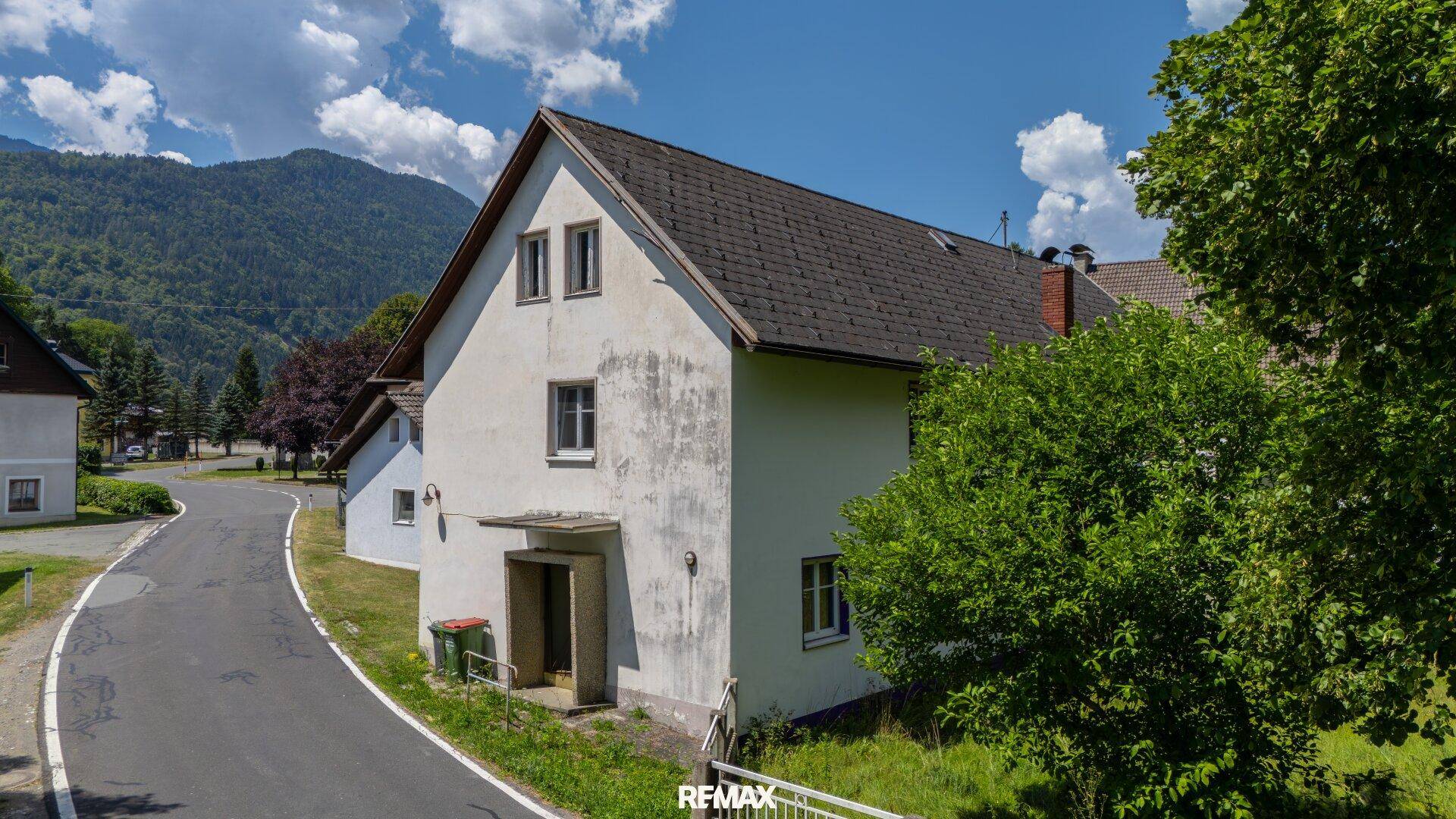 Ansicht des weißen Hauses von der Straße aus mit Bergblick im Hintergrund.