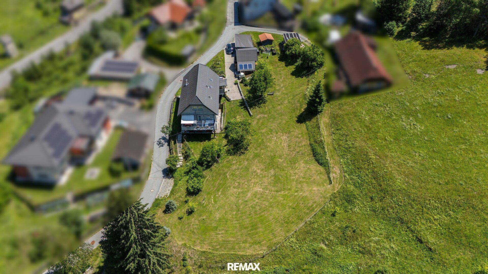 Weitläufige Luftaufnahme des Anwesens mit großem Grundstück und umliegender Naturlandschaft.