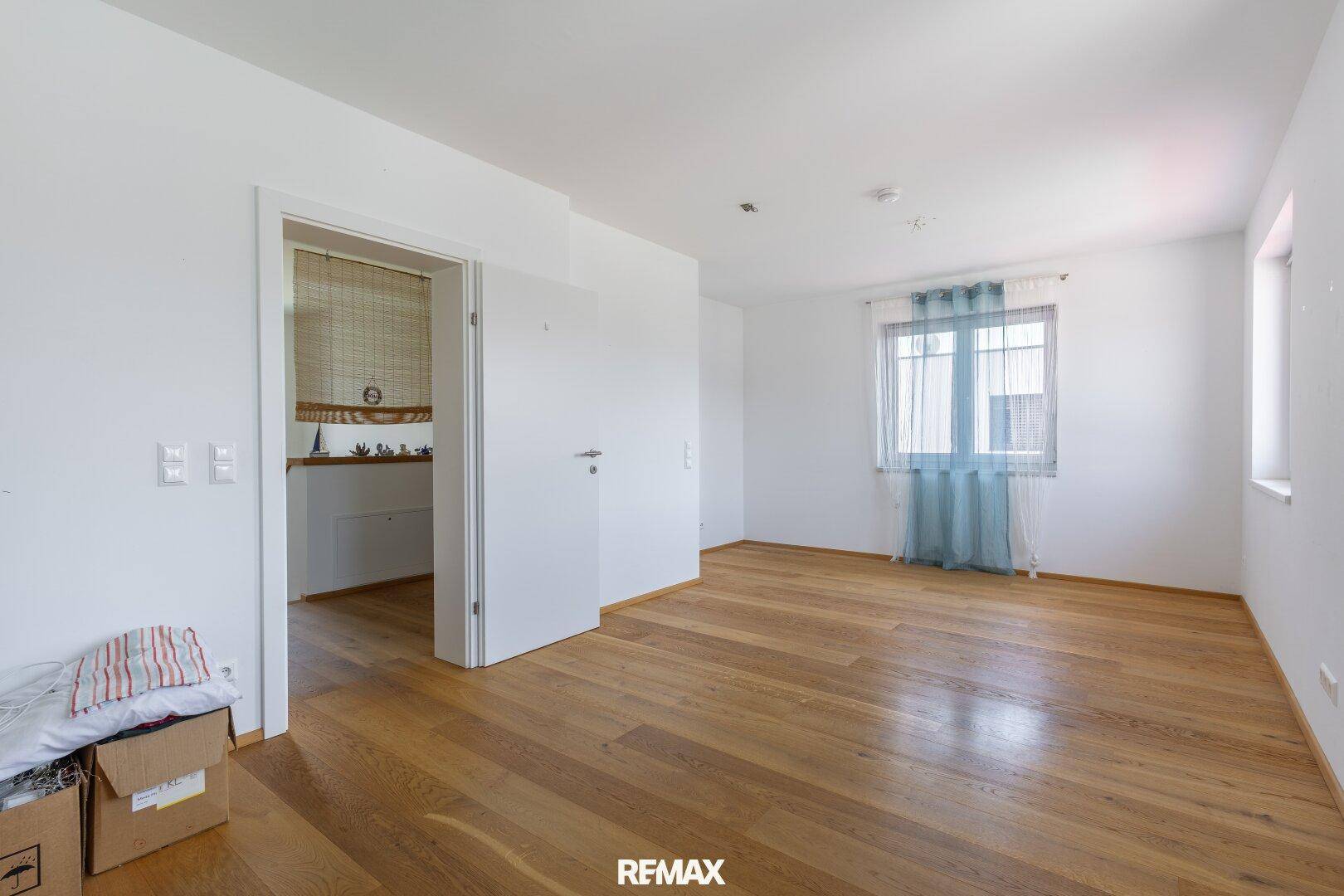 Helles Zimmer mit Holzboden und Fenster, ideal als Schlaf- oder Arbeitszimmer.