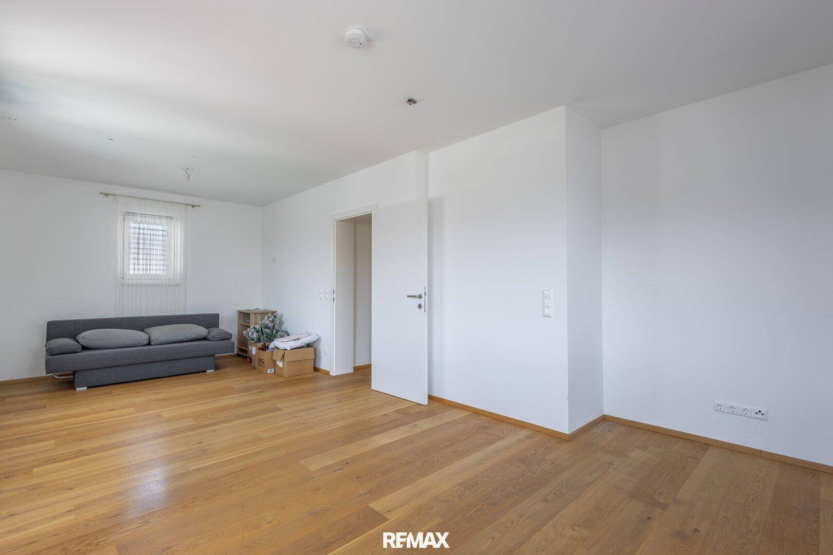 Geräumiges Zimmer mit Holzboden und vielseitigen Nutzungsmöglichkeiten.