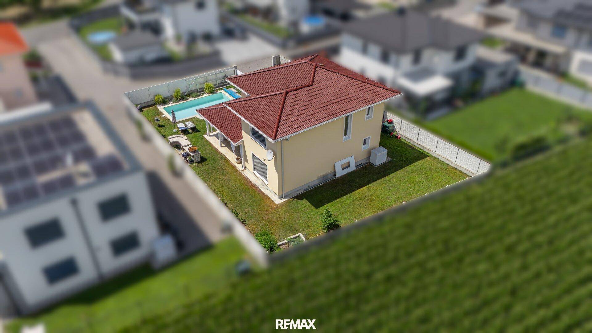 Luftaufnahme des Anwesens mit Pool, Garten und dem angrenzenden Maisfeld.