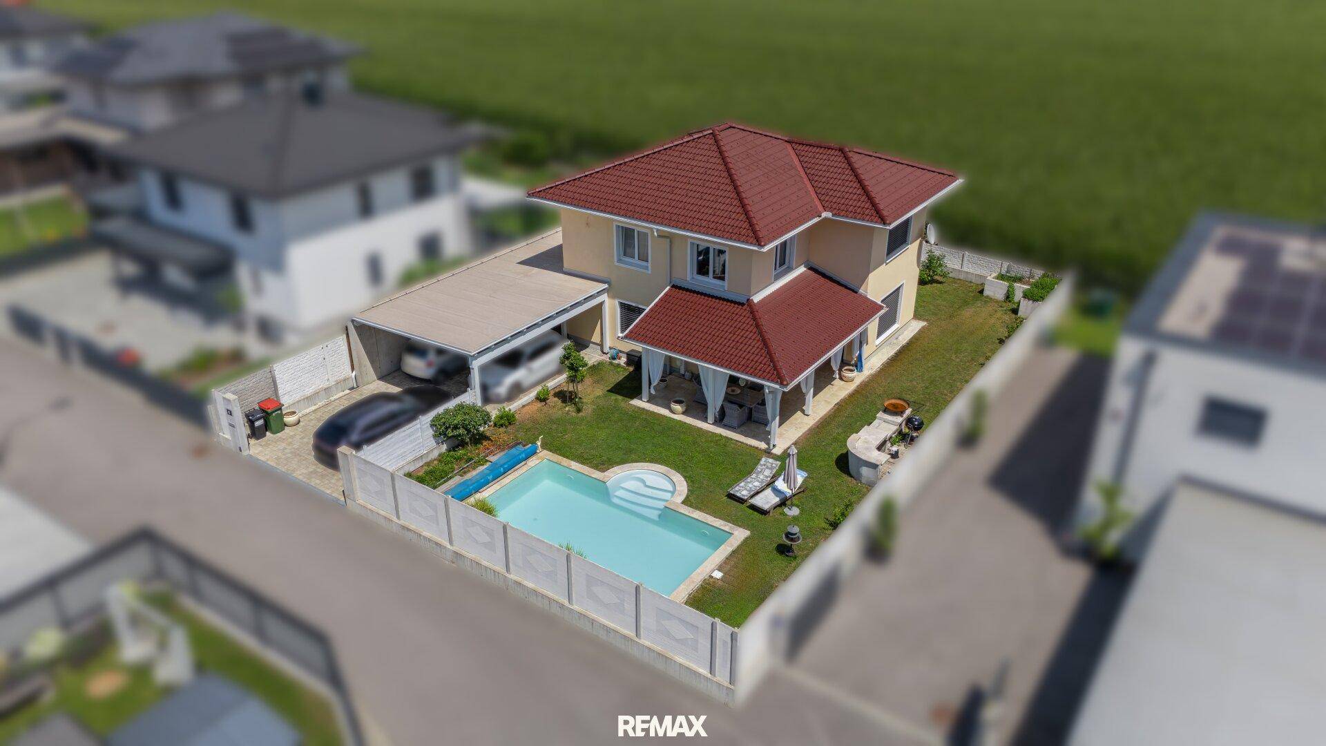 Detaillierte Luftaufnahme des Hauses mit Pool, Carport und gepflegtem Gartenbereich.