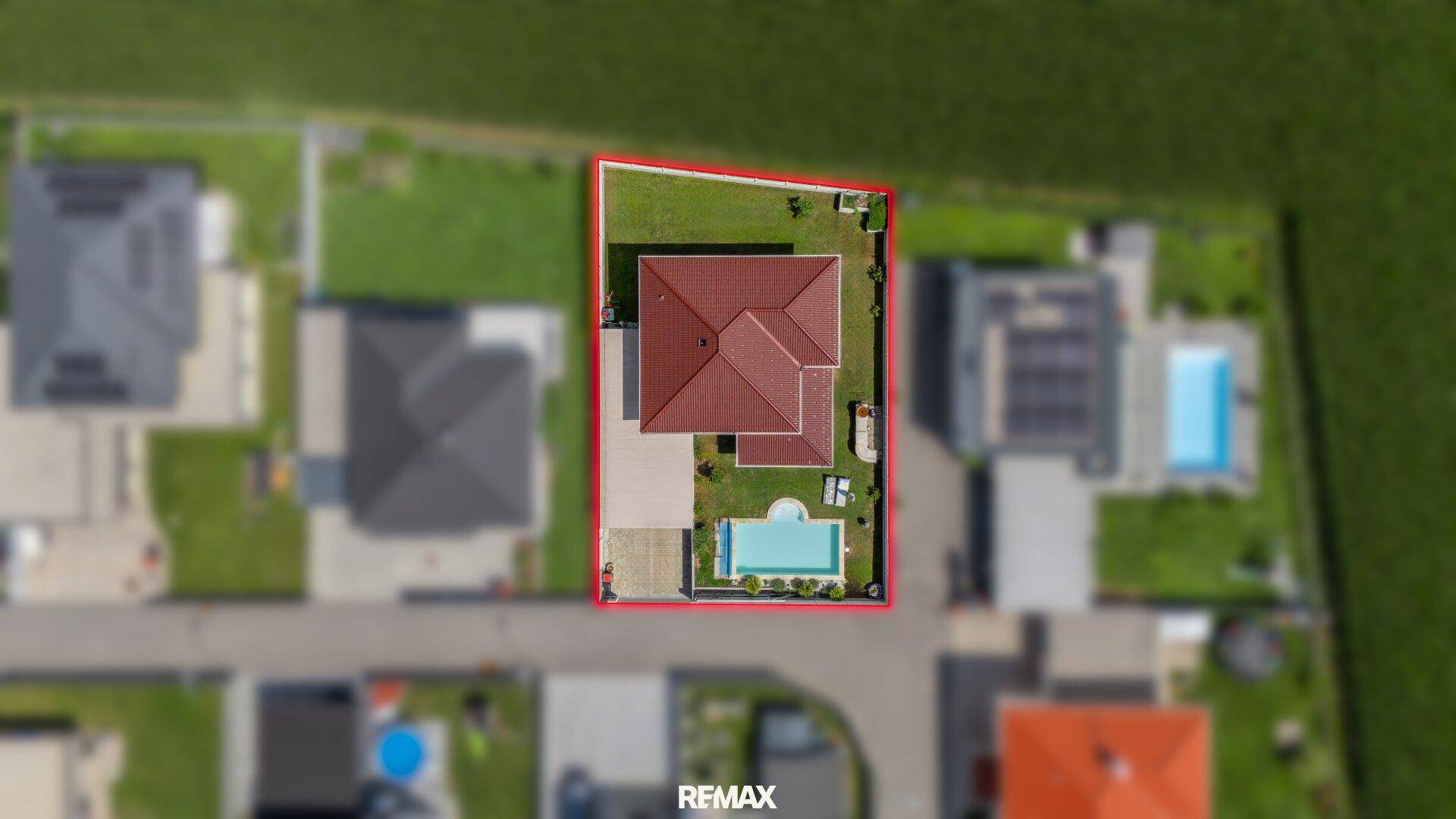 Draufsicht des Grundstücks mit markierter Grenze, Haus, Pool und Carport.