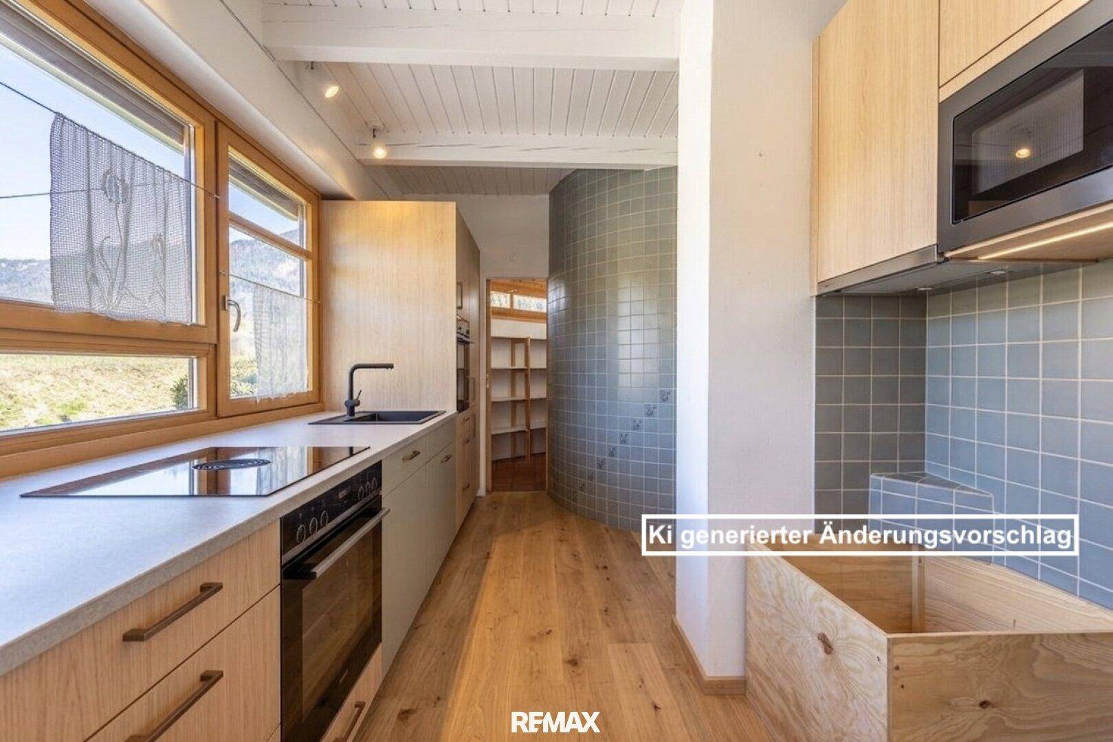 Moderne Küche mit Holzelementen, Induktionskochfeld und integrierten Geräten, mit Blick auf die Berge.