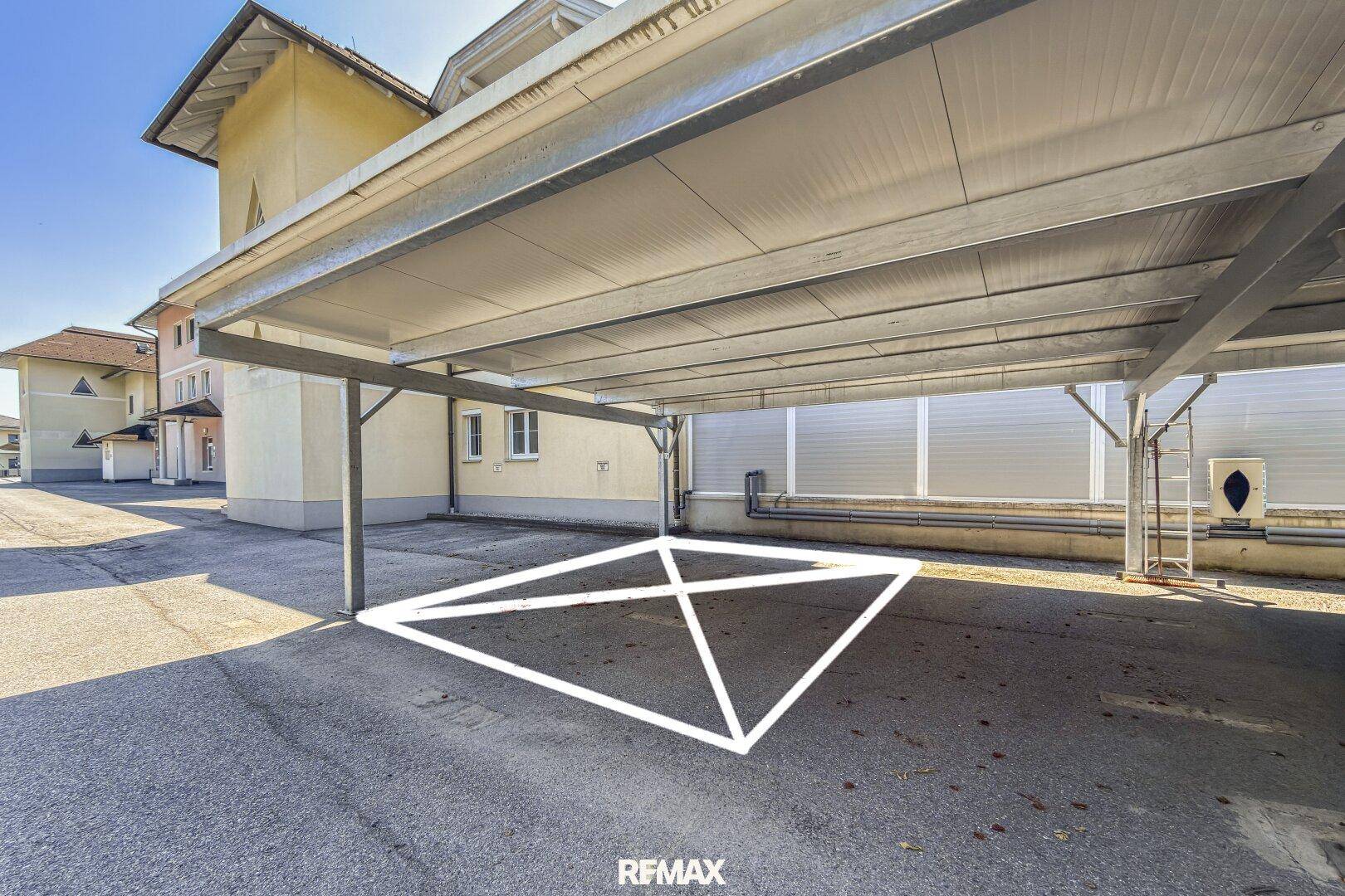 Überdachter Stellplatz im Freien, ideal für ein Fahrzeug, mit Markierung auf dem Boden.