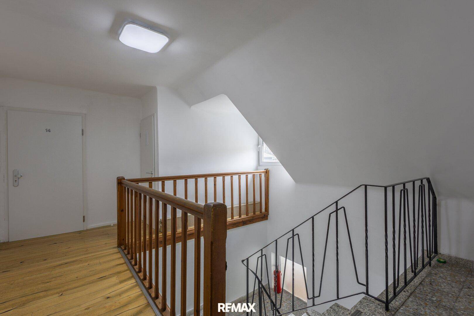 Dachgeschoss-Flur mit Holzgeländer und Treppe, die nach unten führt.