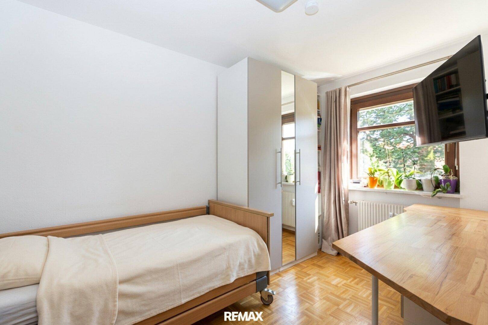 Kinderzimmer oder Gästezimmer mit Einzelbett, Schreibtisch und Blick ins Grüne.