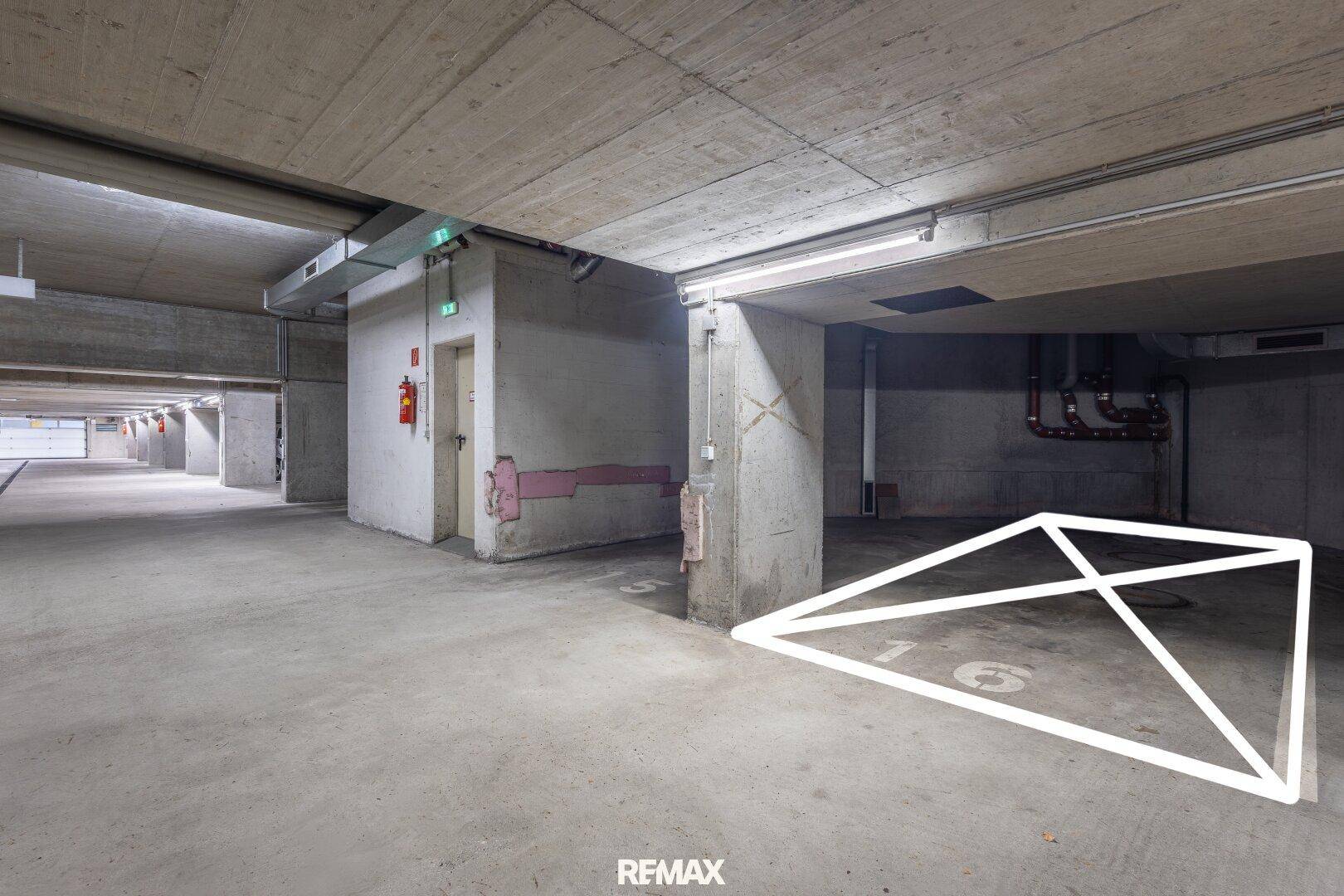 Geräumige Tiefgarage mit Betonboden und markierten Parkplätzen, gut beleuchtet.