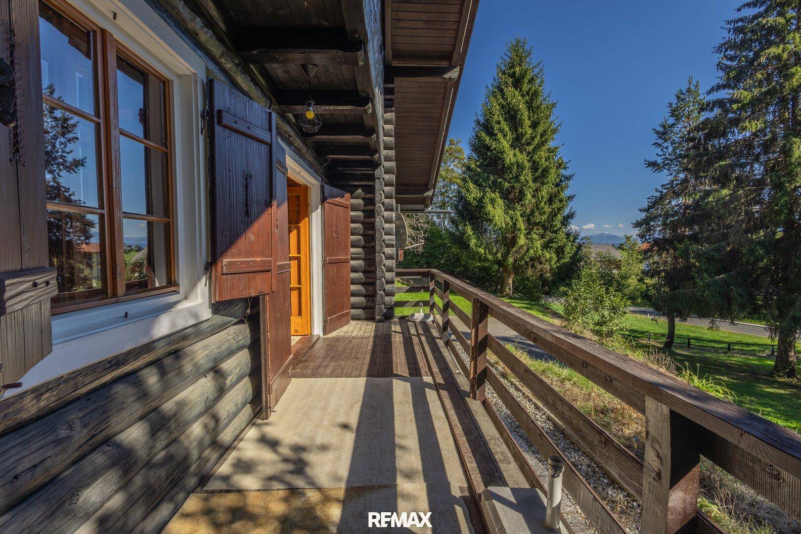 Sonniger Holzbalcon mit weitem Blick über die grüne Natur und die Umgebung.
