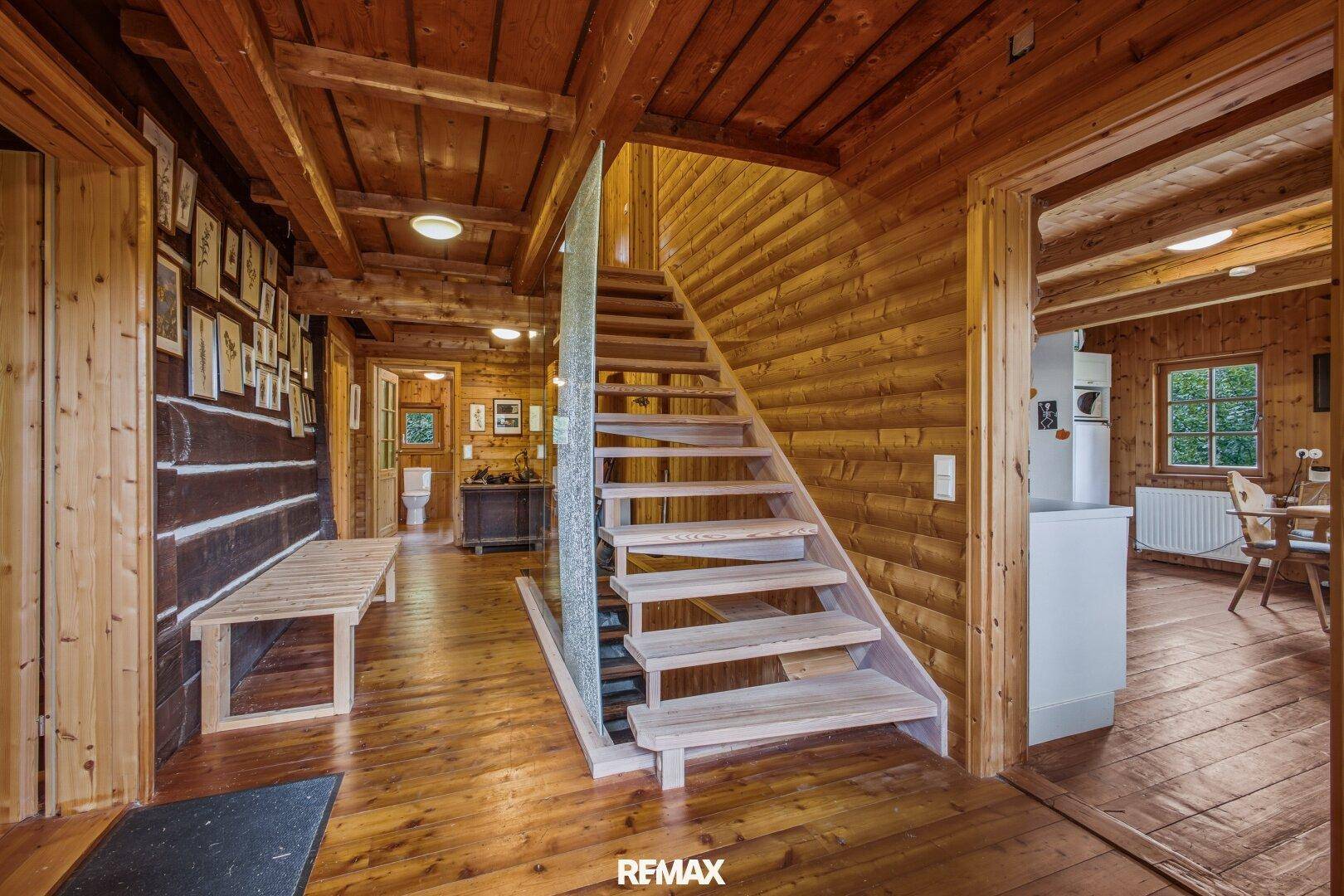 Heller Flur mit Holzboden, Holzwänden und offener Holztreppe.