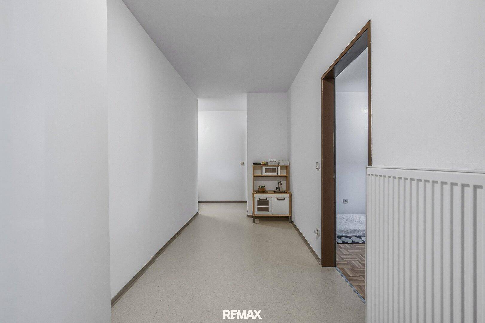 Langer, heller Flur mit Vinylboden und Blick in den hinteren Bereich.