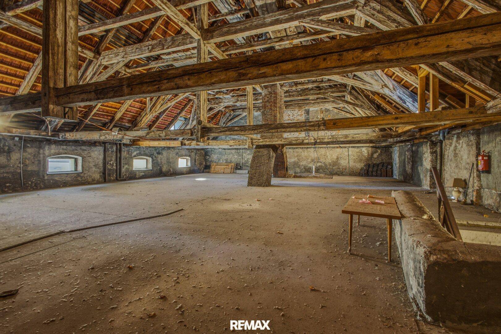 Großer Dachboden mit freiliegenden Holzbalken und viel Potenzial für Ausbau.