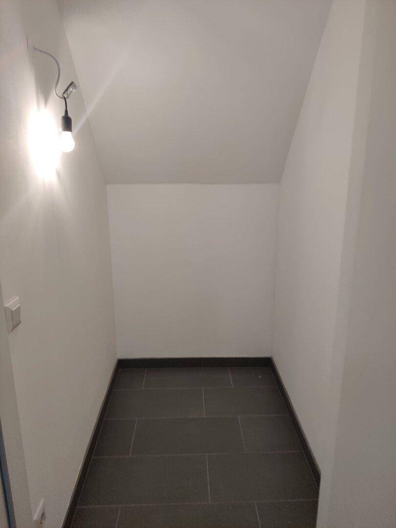 Kleiner Raum mit dunklen Fliesen und weißen Wänden, nutzbar als Abstellraum.