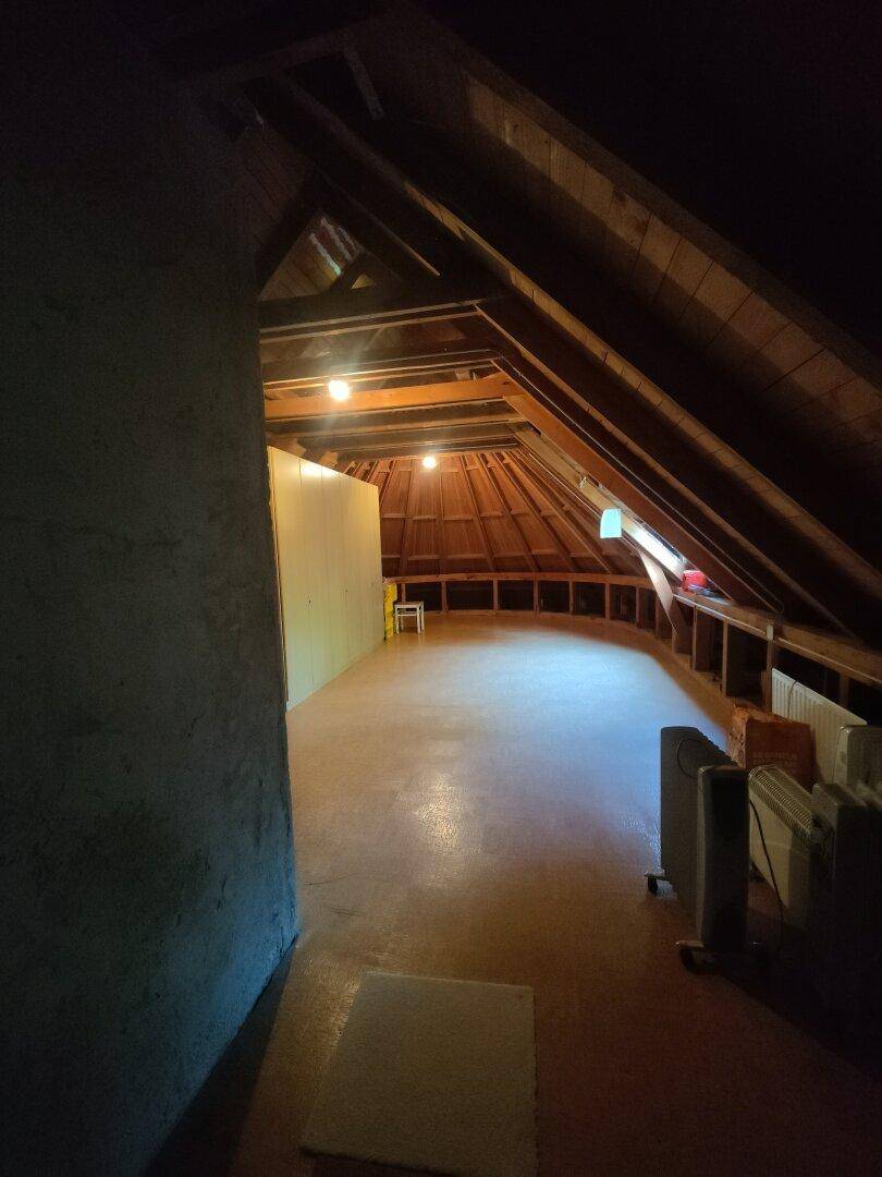 Geräumiger Dachboden mit sichtbaren Holzbalken und schrägen Decken, bietet Ausbaupotenzial.