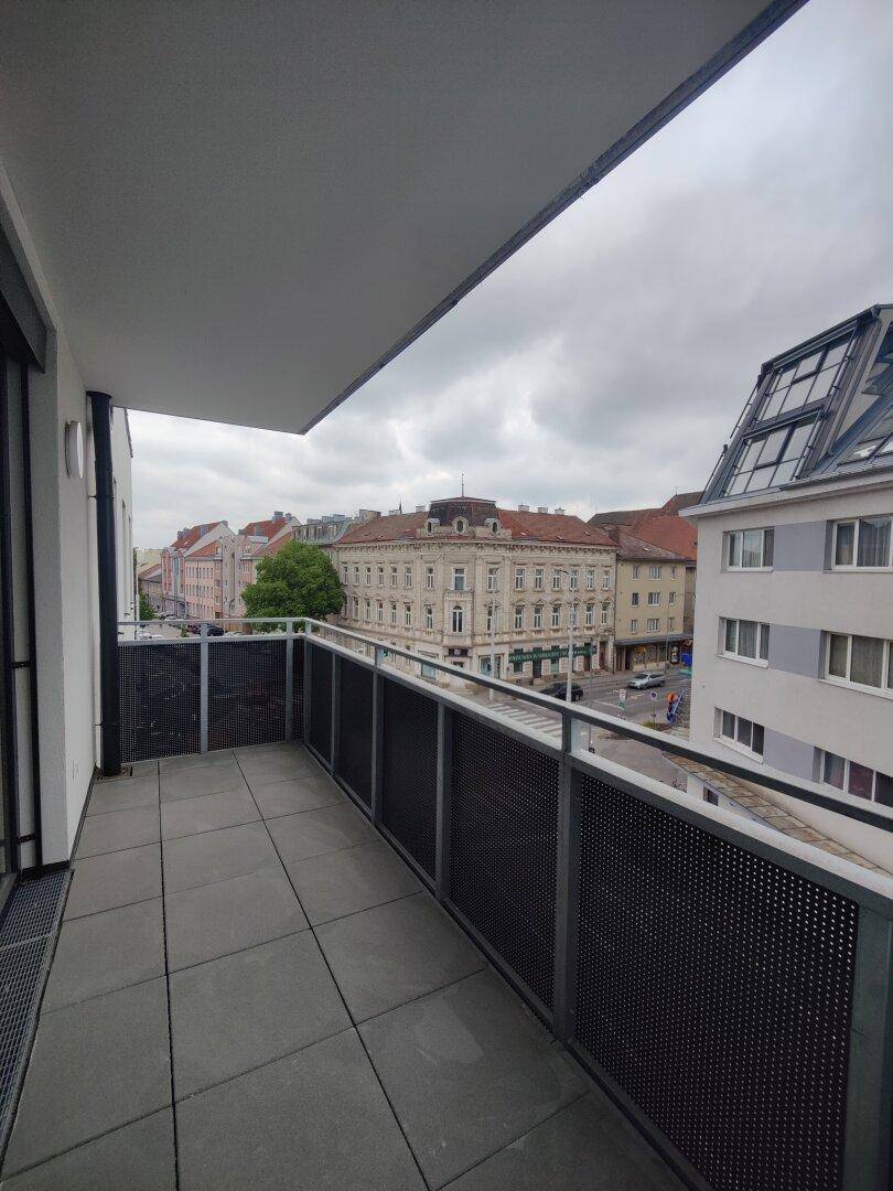 Geräumiger Balkon mit Fliesenboden und weitem Blick über die Stadt.