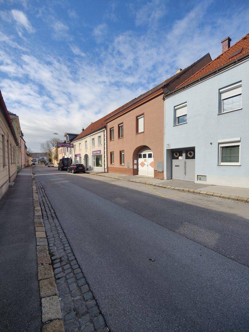 Blick auf eine ruhige Wohnstraße mit mehreren Häusern unter blauem Himmel.